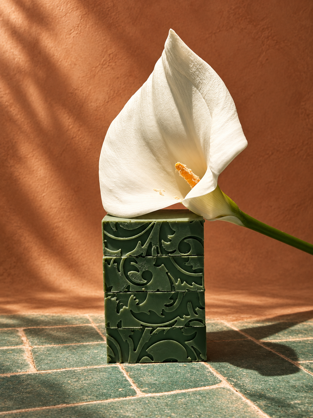 Jabón verde de cáñamo Altaluna Botanicals con alcatraz blanco en una escena de terracota y azulejo verde