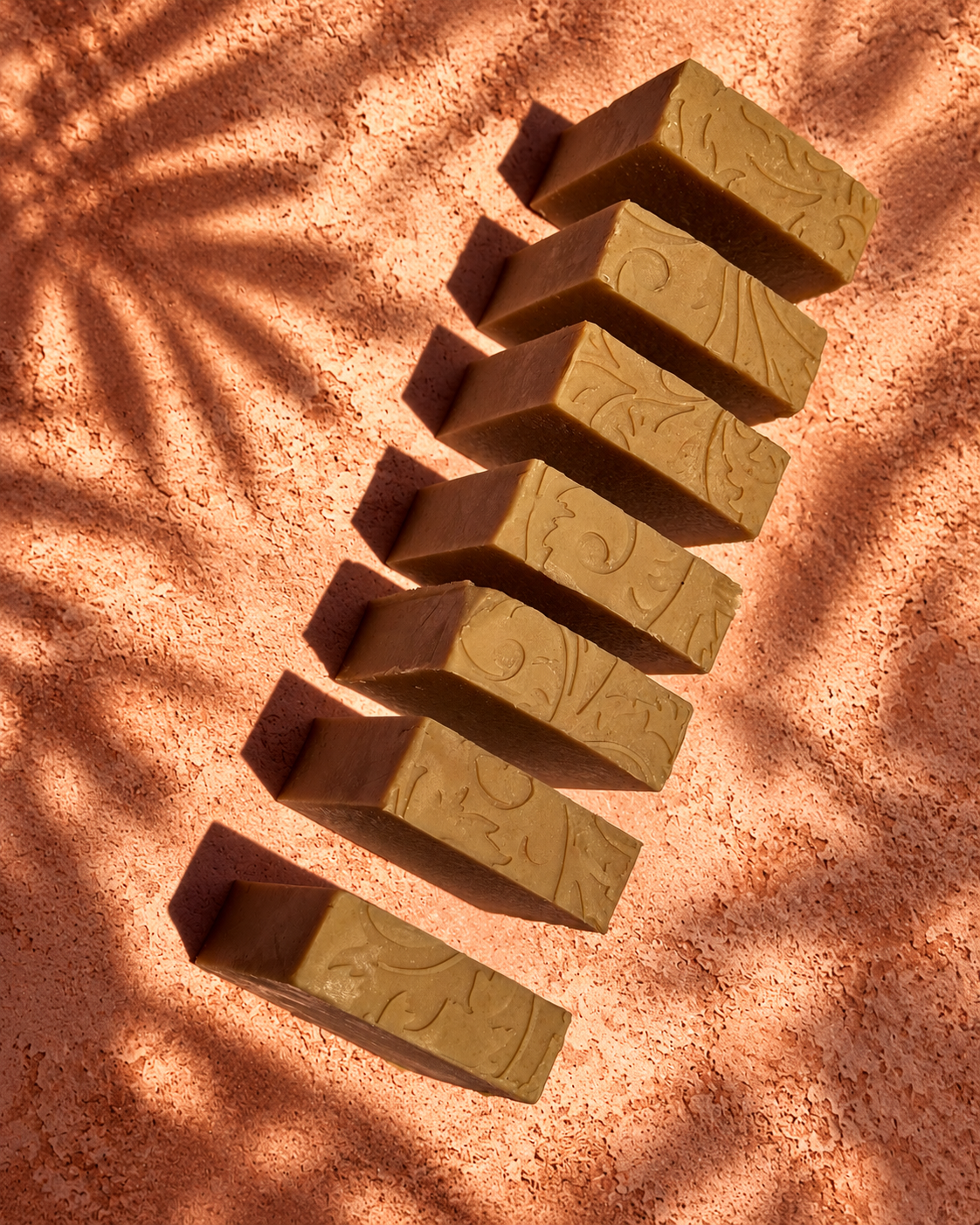 Barras de miel, leche de cabra y avena vistas desde arriba sobre fondo terracota